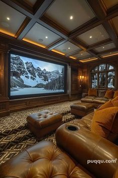 a large living room with leather couches and a big screen tv on the wall