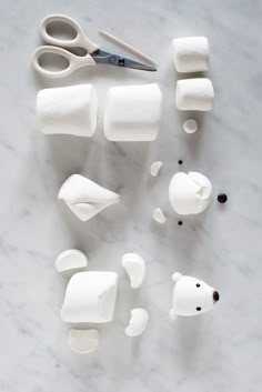 several pieces of white plastic sitting on top of a marble table next to scissors and toothbrushes