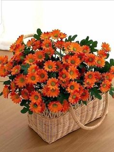 an orange flower arrangement in a wicker basket