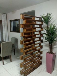 a tall wooden structure sitting next to a plant in a living room filled with furniture