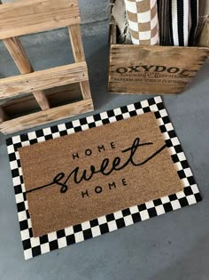 the welcome mat is next to two wooden crates and one has a black and white checkered doormat