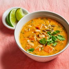 a white bowl filled with soup next to a lime