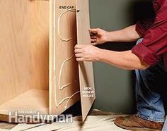 a man is working on a cabinet door