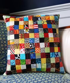 a colorful patchwork pillow sitting on top of a blue chair