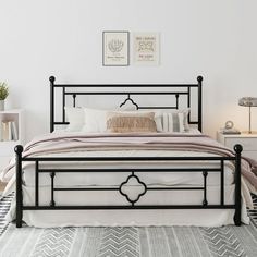 a bedroom with a bed, nightstands and two pictures on the wall above it