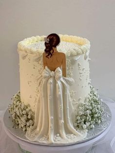 a white wedding cake with an image of a bride and groom on top