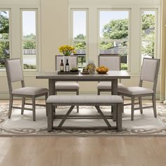 a dining room table with four chairs and a bench