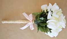 a bouquet of white flowers with a ribbon tied around it