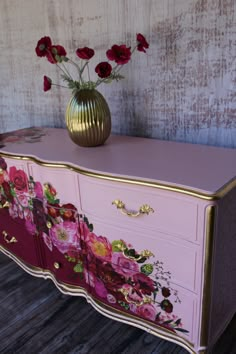 a pink and gold dresser with flowers on it