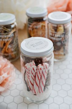 jars filled with candy canes sitting on top of a table