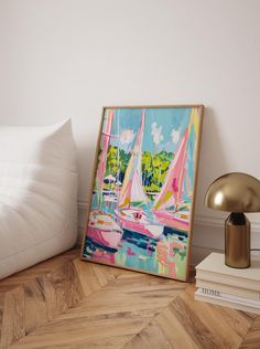 a painting sitting on top of a wooden floor next to a lamp and bookshelf