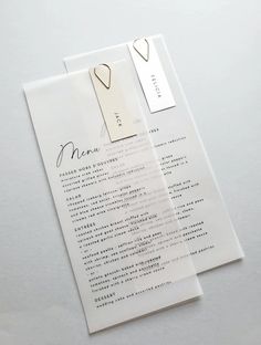 two pieces of paper with some writing on them and tags attached to the back of each piece