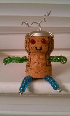 a small toy made out of wine corks and glass beads is sitting on a shelf