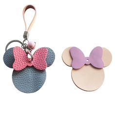 two mickey mouse ears with pink and blue bows are shown on the same keychain