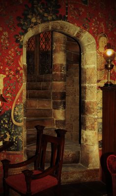 an old brick wall with a painting on it and a wooden chair in the corner