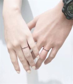 two hands holding each other with rings on their fingers and the words love written across them