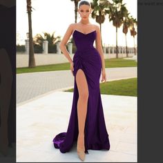 a woman in a purple dress posing for the camera