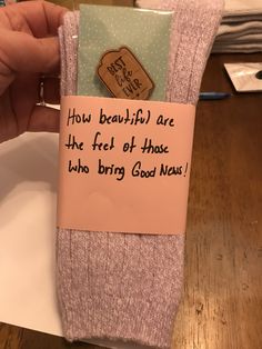 someone is holding up a sock with a note attached to it that says, how beautiful are the feet of those who bring good news