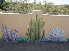 a large cactus mural painted on the side of a wall with succulents and cacti