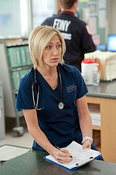 a woman with a stethoscope sitting at a desk in front of a man