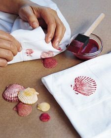 someone is painting seashells on a piece of white paper with red paint and a brush