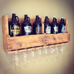 six beer bottles are lined up in a wooden holder