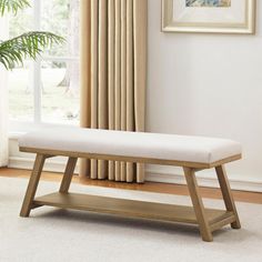 a white bench sitting in front of a window