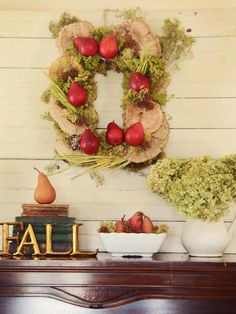 an arrangement of fruit and vegetables is displayed on a mantel with the word fall spelled in gold