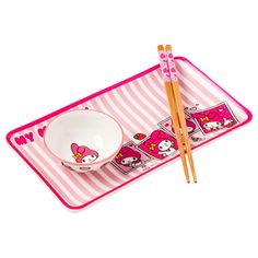 two chopsticks and a bowl with hello kitty designs