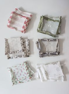 four different square pieces of fabric laid out on a white surface, with one folded and the other unzipped