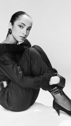 a black and white photo of a woman sitting on the floor with her legs crossed