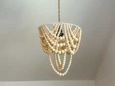 a chandelier made out of wooden beads hanging from a ceiling in a room