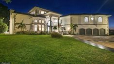 a large white house sitting on top of a lush green field