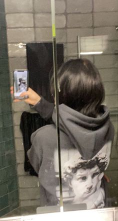 a woman taking a selfie in a bathroom mirror