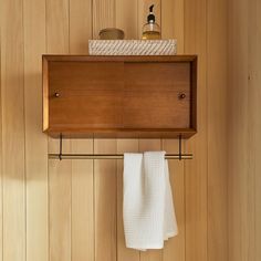 a bathroom with wooden paneling and white towels hanging from the hooks on the wall