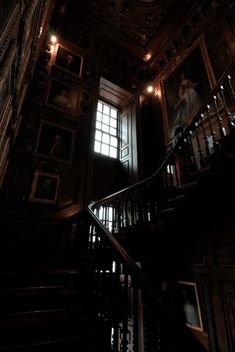 the stairs in an old building are lit up with lights and paintings on the walls