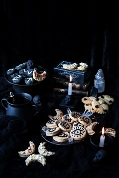 a table topped with cookies and other items on top of a black cloth covered table