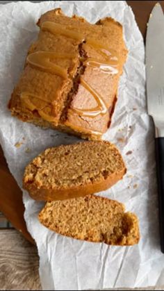 sliced loaf of bread sitting on top of a piece of paper next to a knife