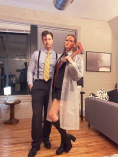 a man and woman dressed up as zombies in a living room with wood flooring