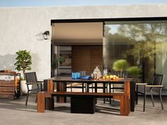 an outdoor table and chairs are set up on the concrete patio with sliding glass doors