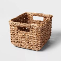 a wicker basket with a handle on the side and a white label in the middle