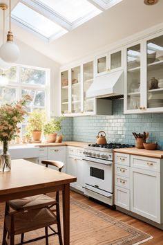 a kitchen with white cabinets and wooden table in front of the stove top oven, potted plants on the counter