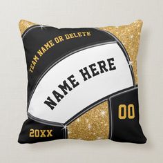 a black and gold pillow with a volleyball ball on the front that says team name or deletee