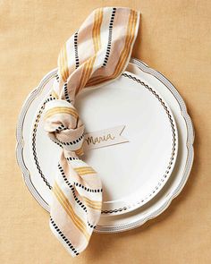 a white plate topped with a yellow and black striped napkin next to a fork and knife