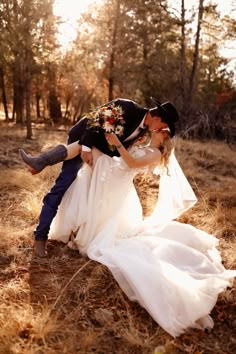 a bride and groom kissing in the woods