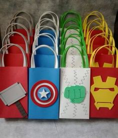 some paper bags that are shaped like superheros and have different designs on the handles