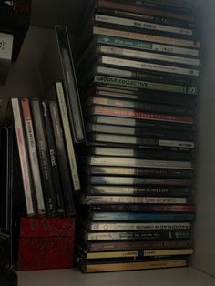 a stack of dvd's sitting on top of a shelf next to a clock