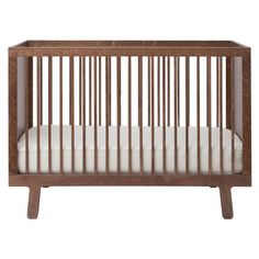 a wooden crib with white sheets on the bottom and side rails, against a white background