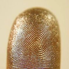 a finger print is shown on top of someone's fingernails in gold