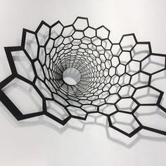 an abstract sculpture is shown in the shape of hexagons on a white wall